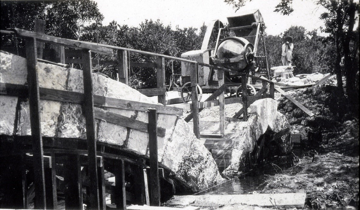 Worker posing with concrete mixer during construction of the Chinese Bridge in 1916 on today's 72 Avenue