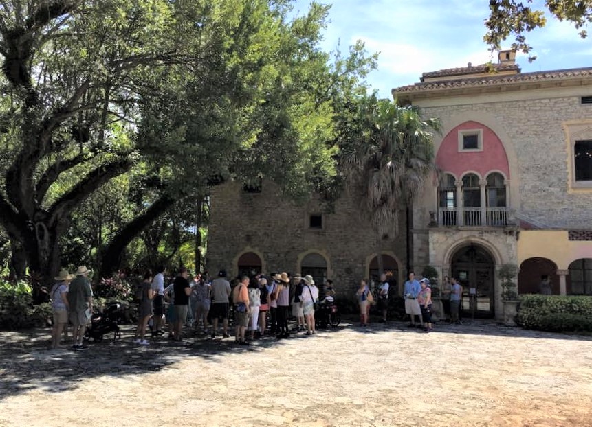 Small group gathered at the Stone House courtyard, examining the Spanish architecture of the Stone House