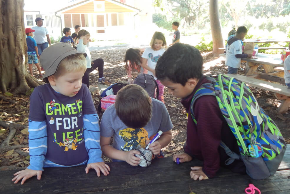 Group of children working on an experiment together during one of Deering Estate's interactive field trips