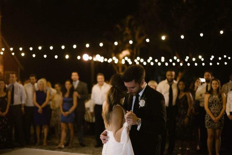 A bride and groom dance slowly and closely together at their wedding reception.