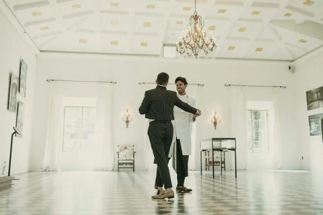 Grooms posing for a picture inside Deering Estate's Stone House grand hall ballroom
