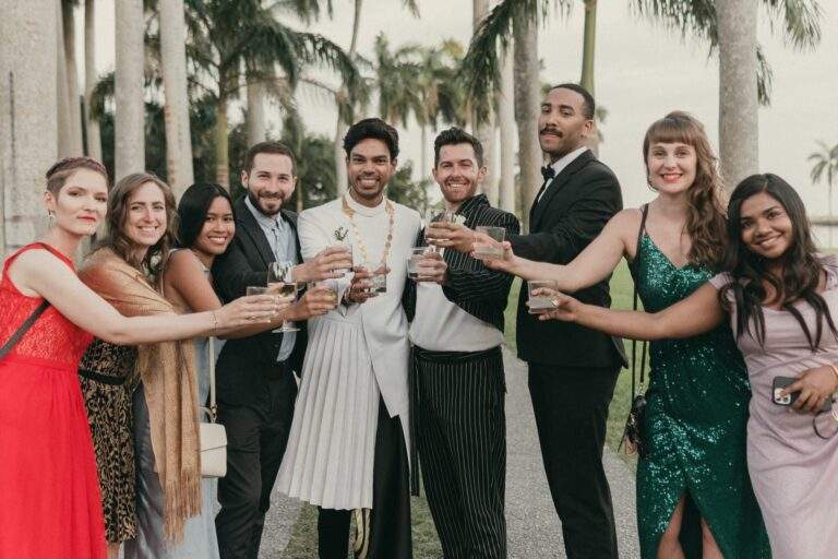 Grooms toasting with some of their wedding guests taking a photo at Deering Estate's Royal Palm Grove