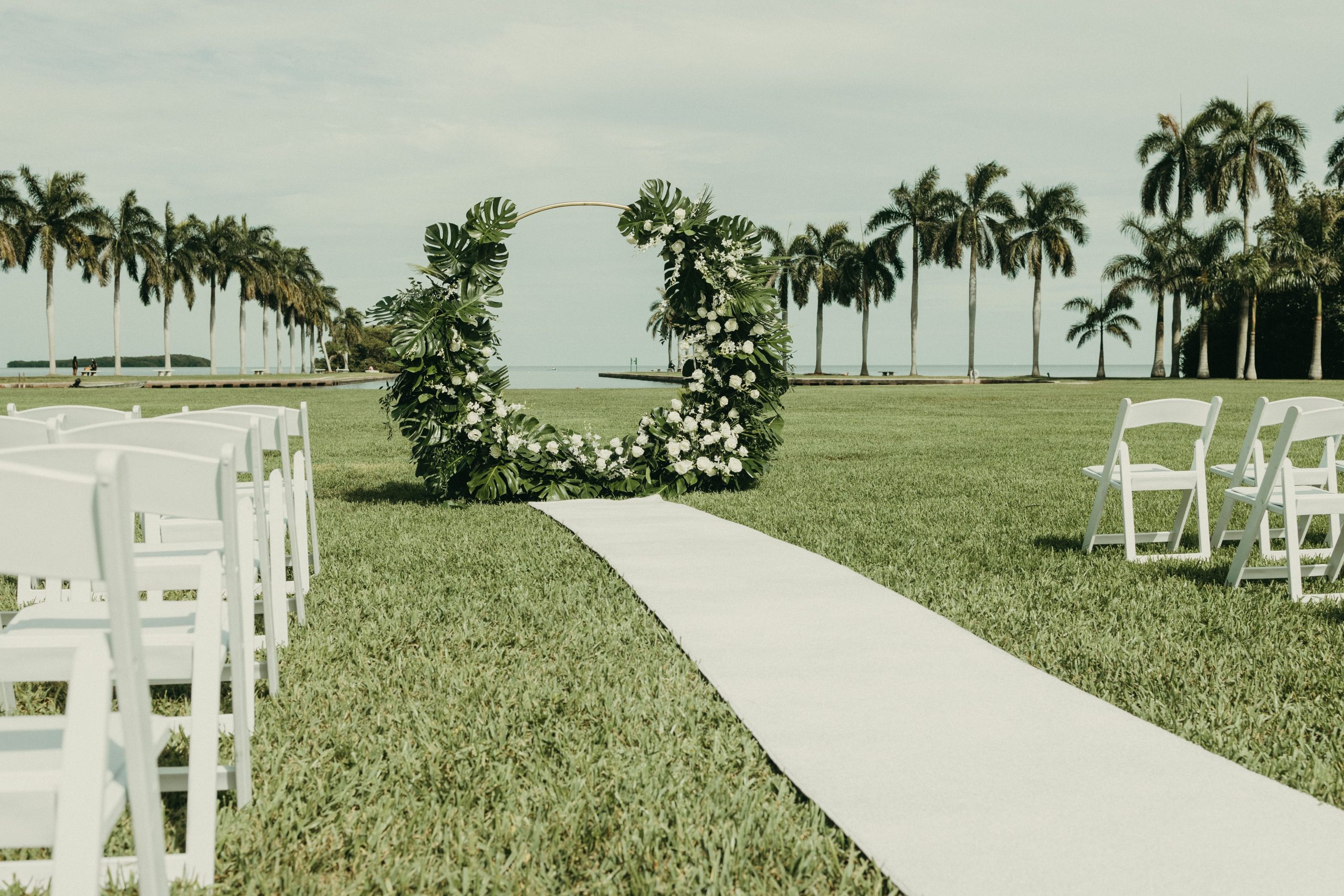 Detail photo of the wedding ceremony arch and aisle at Deering Estate's waterfront lawn