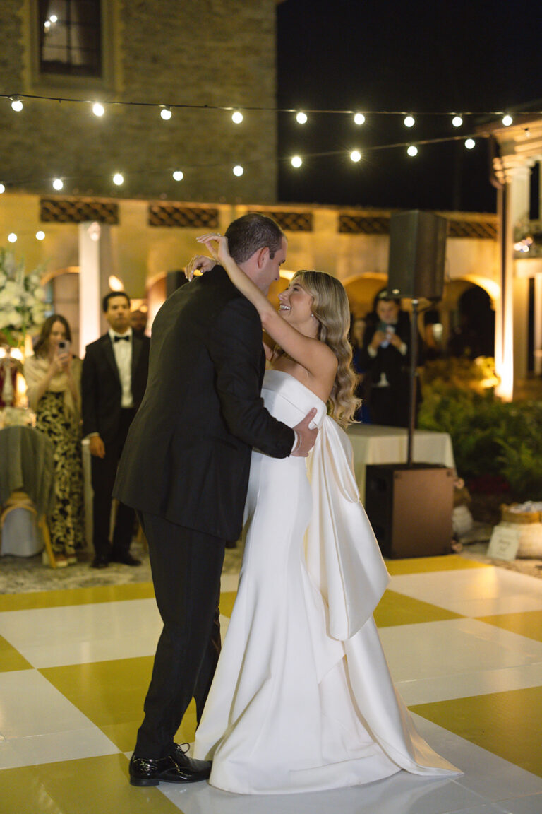 A bride and groom looking lovingly at each other as they dance together at their wedding.