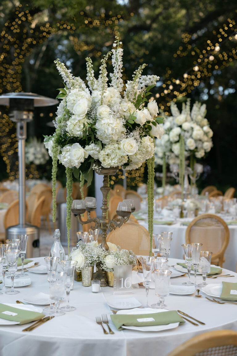 A table setting with large floral centerpiece for a wedding.