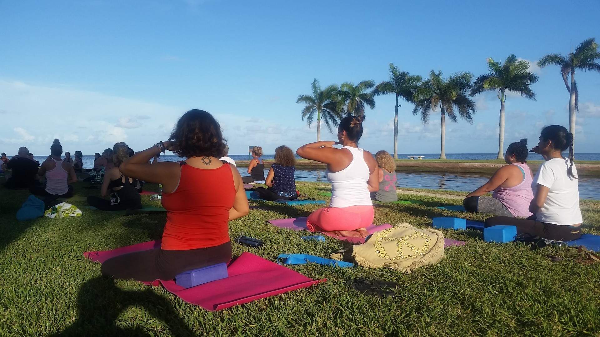 Deering Estate hosting a yoga class taking place on the grass near the beach