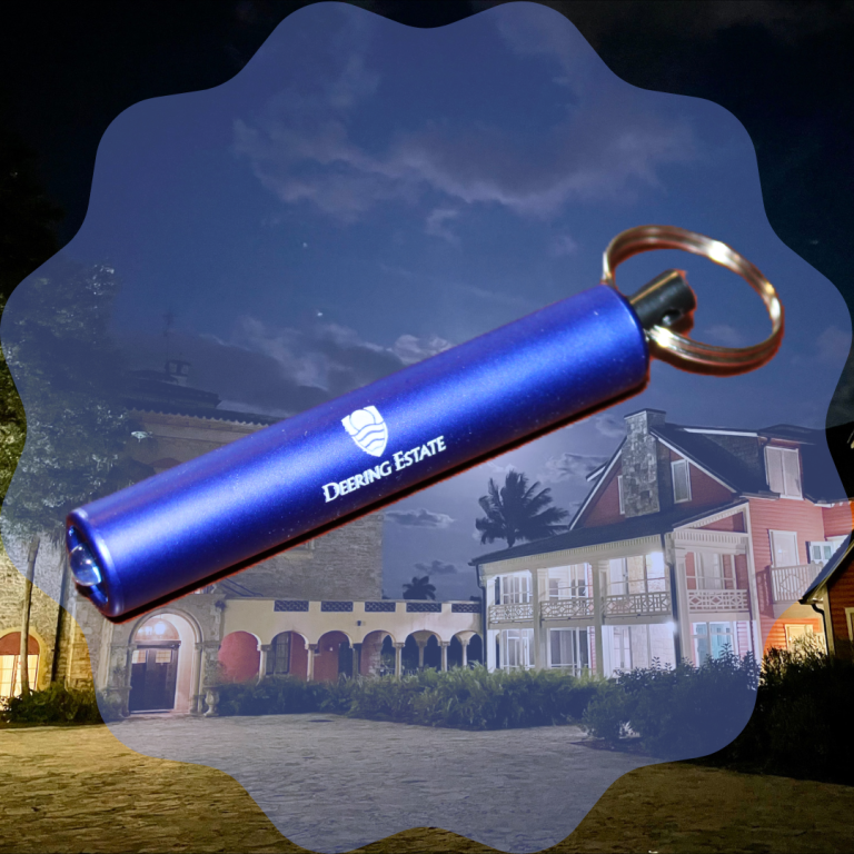 An image of a Deering Estate-branded flashlight keychain superimposed onto an image of the Stone House and Richmond Cottage.